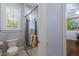 Bright bathroom featuring a tiled walk-in shower, toilet, and natural light from a window at 7211 Pasadena Gln, Lakewood Ranch, FL 34202
