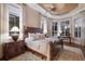 Bright bedroom features a unique ceiling detail, plantation shutters, and dark wood furniture at 7211 Pasadena Gln, Lakewood Ranch, FL 34202
