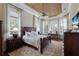 Spacious bedroom boasts a unique ceiling detail, elegant wood furniture, and lots of natural light at 7211 Pasadena Gln, Lakewood Ranch, FL 34202
