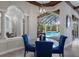Dining area with blue chairs overlooks the screened-in pool area at 7211 Pasadena Gln, Lakewood Ranch, FL 34202