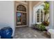 Stunning front door with glass details and an arched window, surrounded by lush landscaping at 7211 Pasadena Gln, Lakewood Ranch, FL 34202