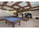 Well-appointed game room with a pool table, seating area, coffered ceilings, wet bar and entertainment center for relaxation at 7211 Pasadena Gln, Lakewood Ranch, FL 34202