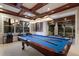 Well-lit game room with a pool table, coffered ceilings, a dart board, and a scenic view through expansive windows at 7211 Pasadena Gln, Lakewood Ranch, FL 34202