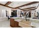 A well-lit kitchen features wooden ceiling beams and an island with a farmhouse sink and granite countertop at 7211 Pasadena Gln, Lakewood Ranch, FL 34202
