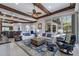 The open-concept living room features wood ceiling beams and access to a patio and outdoor kitchen at 7211 Pasadena Gln, Lakewood Ranch, FL 34202