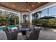 Outdoor living space with a fireplace, seating area, and a view of the pool and landscaping at 7211 Pasadena Gln, Lakewood Ranch, FL 34202
