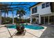 A screened-in pool with palm trees visible through the screen and an outdoor seating area at 7211 Pasadena Gln, Lakewood Ranch, FL 34202