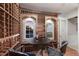 Elegant wine cellar with custom wood racks, arched windows, mural, and a cozy table with seating for wine tasting at 7211 Pasadena Gln, Lakewood Ranch, FL 34202