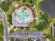 Aerial view of community pool with ample seating, playground, and parking near a pond at 7424 Sea Island Ln, Bradenton, FL 34201