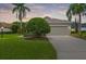 A well-maintained home with a manicured lawn, mature tree, and inviting driveway leading to a two-car garage at 7424 Sea Island Ln, Bradenton, FL 34201