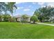 Well-manicured front yard with lush green grass, mature trees, and beautiful landscaping at 7424 Sea Island Ln, Bradenton, FL 34201