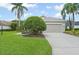 Two car garage with driveway, mature landscaping, and a well-maintained lawn at 7424 Sea Island Ln, Bradenton, FL 34201