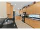 Well-lit kitchen with wood cabinets, black countertops, and modern appliances, offering ample storage and workspace at 7424 Sea Island Ln, Bradenton, FL 34201
