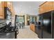 Open kitchen featuring wood cabinets, black appliances, and a view of the dining area and backyard at 7424 Sea Island Ln, Bradenton, FL 34201