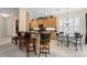 Open kitchen with bar-style seating, black countertops, stainless appliances, and white shutters at 7424 Sea Island Ln, Bradenton, FL 34201