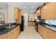 Well-lit kitchen with black granite countertops, wood cabinets, and stainless steel appliances at 7424 Sea Island Ln, Bradenton, FL 34201