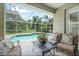 Inviting screened-in pool area with patio seating, overlooking lush greenery at 7424 Sea Island Ln, Bradenton, FL 34201