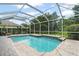 Inviting pool area with brick patio, screened enclosure, and lush landscaping at 7424 Sea Island Ln, Bradenton, FL 34201
