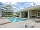 Private screened-in pool with brick paver deck and lush landscaping, perfect for outdoor entertaining at 7424 Sea Island Ln, Bradenton, FL 34201