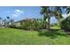 Expansive backyard with green grass, tropical landscaping, and a screened-in pool at 7717 Us Open Loop, Lakewood Ranch, FL 34202
