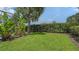 Lush backyard features a well-kept lawn and privacy landscaping around the pool area at 7717 Us Open Loop, Lakewood Ranch, FL 34202