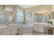 Bright bathroom featuring double sinks, a soaking tub, and updated fixtures and lighting at 7717 Us Open Loop, Lakewood Ranch, FL 34202