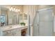 Bathroom featuring a shower with glass doors, single sink with updated faucet, and vanity with drawers at 7717 Us Open Loop, Lakewood Ranch, FL 34202