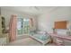 Bright bedroom with a large window, pink accents, and a view of the landscaped yard at 7717 Us Open Loop, Lakewood Ranch, FL 34202