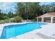 Enjoy the community pool with a covered area for relaxing and entertaining amidst lush greenery and sunny skies at 7717 Us Open Loop, Lakewood Ranch, FL 34202