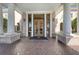 Grand entryway features double doors, elegant columns, and a decorative brick floor at 7717 Us Open Loop, Lakewood Ranch, FL 34202