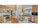 Bright kitchen features stainless appliances, granite counters, and center island with wood cabinets at 7717 Us Open Loop, Lakewood Ranch, FL 34202