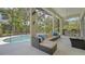 Relaxing screened-in lanai features seating, outdoor kitchen, and view of the pool at 7717 Us Open Loop, Lakewood Ranch, FL 34202