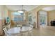 Open-concept living room with dining area boasts hardwood floors, large windows, and neutral paint at 7717 Us Open Loop, Lakewood Ranch, FL 34202
