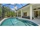 Sparkling pool in a screened enclosure, adjacent to a covered patio and outdoor kitchen at 7717 Us Open Loop, Lakewood Ranch, FL 34202