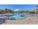 Outdoor pool area features a fountain, lounge chairs, and sun umbrellas on a sunny day at 7717 Us Open Loop, Lakewood Ranch, FL 34202