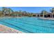A long outdoor swimming pool with lane markers, surrounded by chairs and umbrellas on a sunny day at 7717 Us Open Loop, Lakewood Ranch, FL 34202