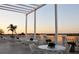 Relaxing rooftop terrace with elegant white furniture and a pergola, perfect for enjoying scenic views at 7717 Us Open Loop, Lakewood Ranch, FL 34202