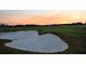 Golf course sand trap at sunset featuring manicured green grass and tranquil atmosphere for a relaxing game at 7717 Us Open Loop, Lakewood Ranch, FL 34202