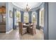 Bright dining area with a chandelier, a wood table, and a view of lush greenery through large windows at 7840 34Th Ave W # 303, Bradenton, FL 34209