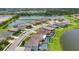 Aerial view showcasing a neighborhood near a lake, complete with houses with private screened pools at 7930 111Th Ter E, Parrish, FL 34219