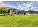 Spacious backyard featuring a screened pool enclosure, complemented by a well-kept lawn at 7930 111Th Ter E, Parrish, FL 34219
