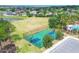 Aerial view of community basketball court with green and blue surface, surrounded by a pond and neighborhood homes at 7930 111Th Ter E, Parrish, FL 34219