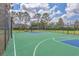 A fenced outdoor basketball court with a green and blue surface, hoop, and seating in a residential area at 7930 111Th Ter E, Parrish, FL 34219
