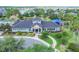 View of a community clubhouse featuring a manicured garden, lush green trees, and a walkway at 7930 111Th Ter E, Parrish, FL 34219
