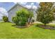Well-maintained lawn with mature trees and landscape beds accenting the gray exterior at 7930 111Th Ter E, Parrish, FL 34219