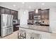 Modern kitchen with dark cabinets, granite counters, stainless appliances, and breakfast bar seating at 7930 111Th Ter E, Parrish, FL 34219