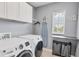 Well organized laundry room with modern appliances, overhead cabinets, and natural light at 7930 111Th Ter E, Parrish, FL 34219