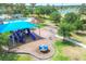A community playground with a blue shade, playground equipment, swings, and a merry-go-round for neighborhood children at 7930 111Th Ter E, Parrish, FL 34219