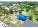 A community playground featuring a blue shade, playground equipment, swings, and seating located in a Gathering-friendly neighborhood at 7930 111Th Ter E, Parrish, FL 34219