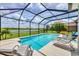 Relaxing pool area with lounge chairs, screened enclosure, and serene lake views at 7930 111Th Ter E, Parrish, FL 34219